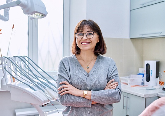 Woman standing in dentist’s office with her arms folded